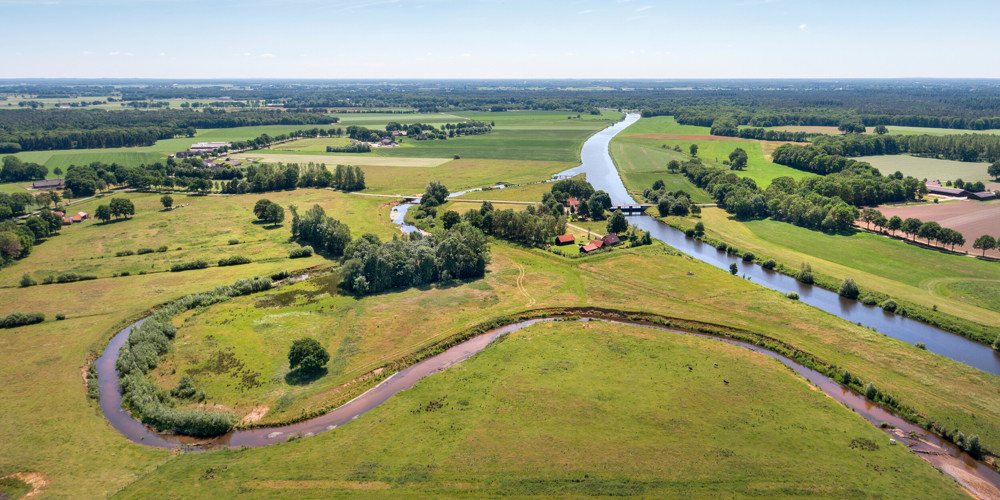 Vogelperspectief landschap vol met bomen en sloten ertussen