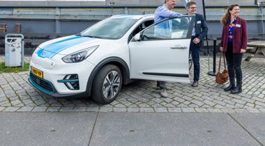 Drie mensen staan bij de provincie werkauto 