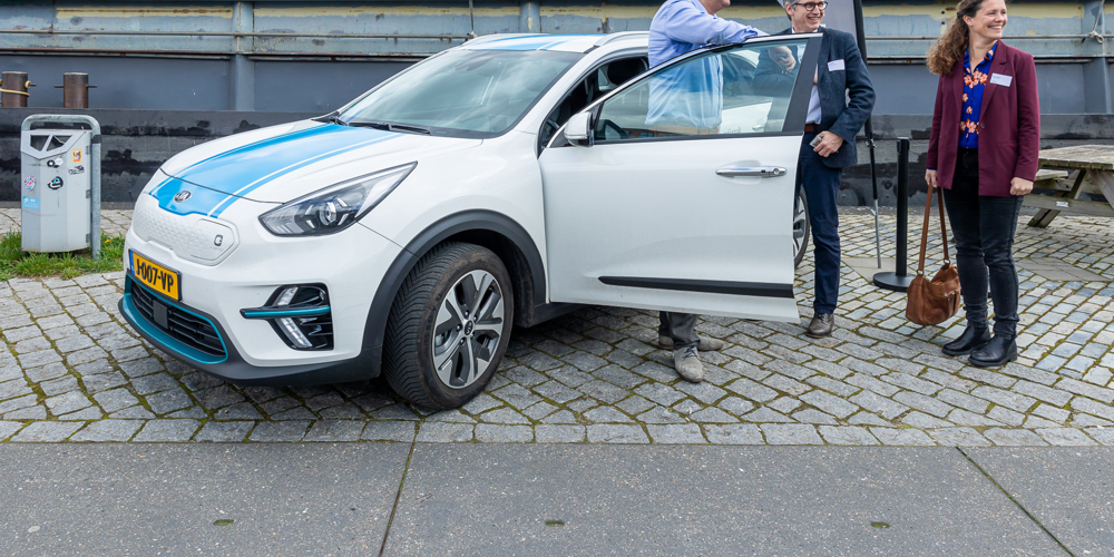 Drie mensen staan bij de provincie werkauto 