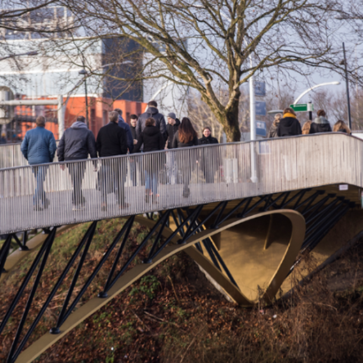 Groep mensen die over een voetgangersloopbrug lopen