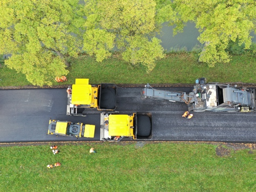 Foto van bovenaf genomen van het asfalteren van een wegdek 