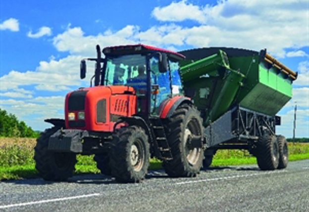 Tractor met groene aanhanger op weg