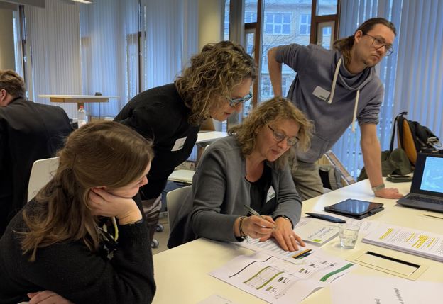 4 mensen kijken samen naar een document