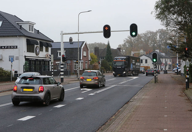 auto's voor een stoplichten, huizen aan de kant van de weg
