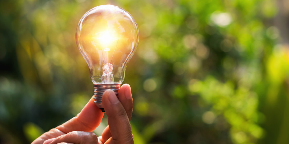 Hand houdt brandende lamp vast