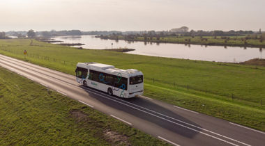 Bus op eenverkeersweg tussen weilanden