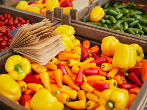 Veel verschillende groenten in een bak op een marktkraam