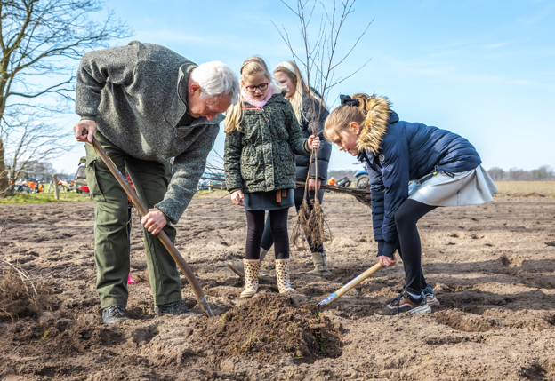 Grootvader met kinderen planten een boom