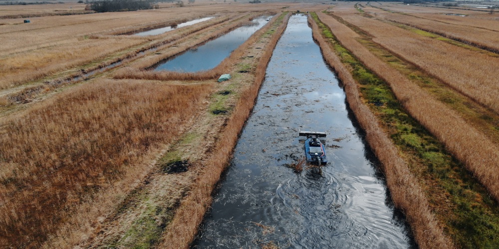 Luchtfoto harkboot in Wieden-Weerribben aan het werk (fotograaf Henk Jan Tobbe)